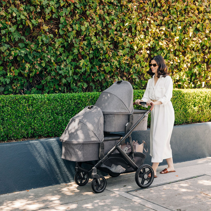 Mom pushes two babies in bassinet attachments on UPPAbaby VISTA V3 Stroller - GREYSON (Charcoal Melange)