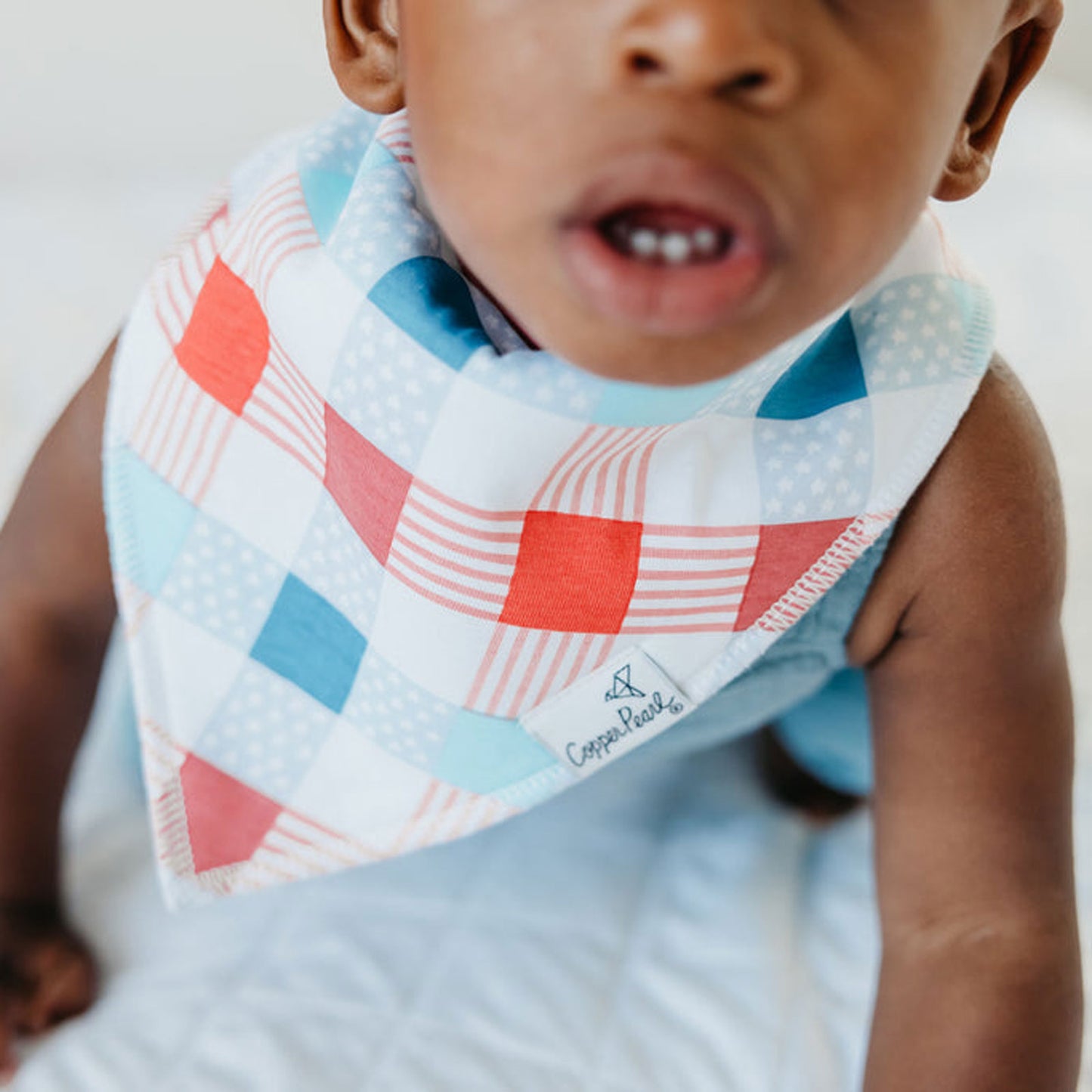 Baby wearing Copper Pearl Single Holiday Bandana Bib - Spangled Check