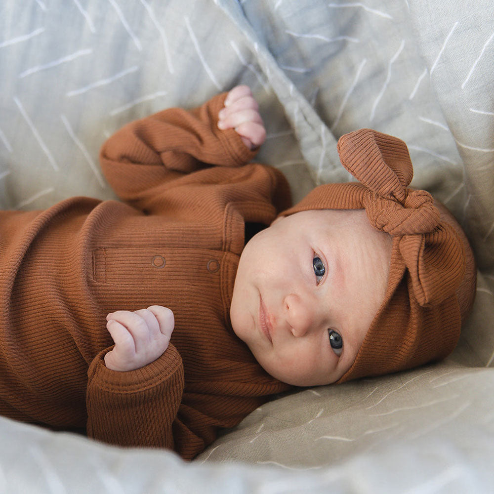 Newborn baby girl wears Mebie Baby Organic Cotton Ribbed Knot Gown - Rust