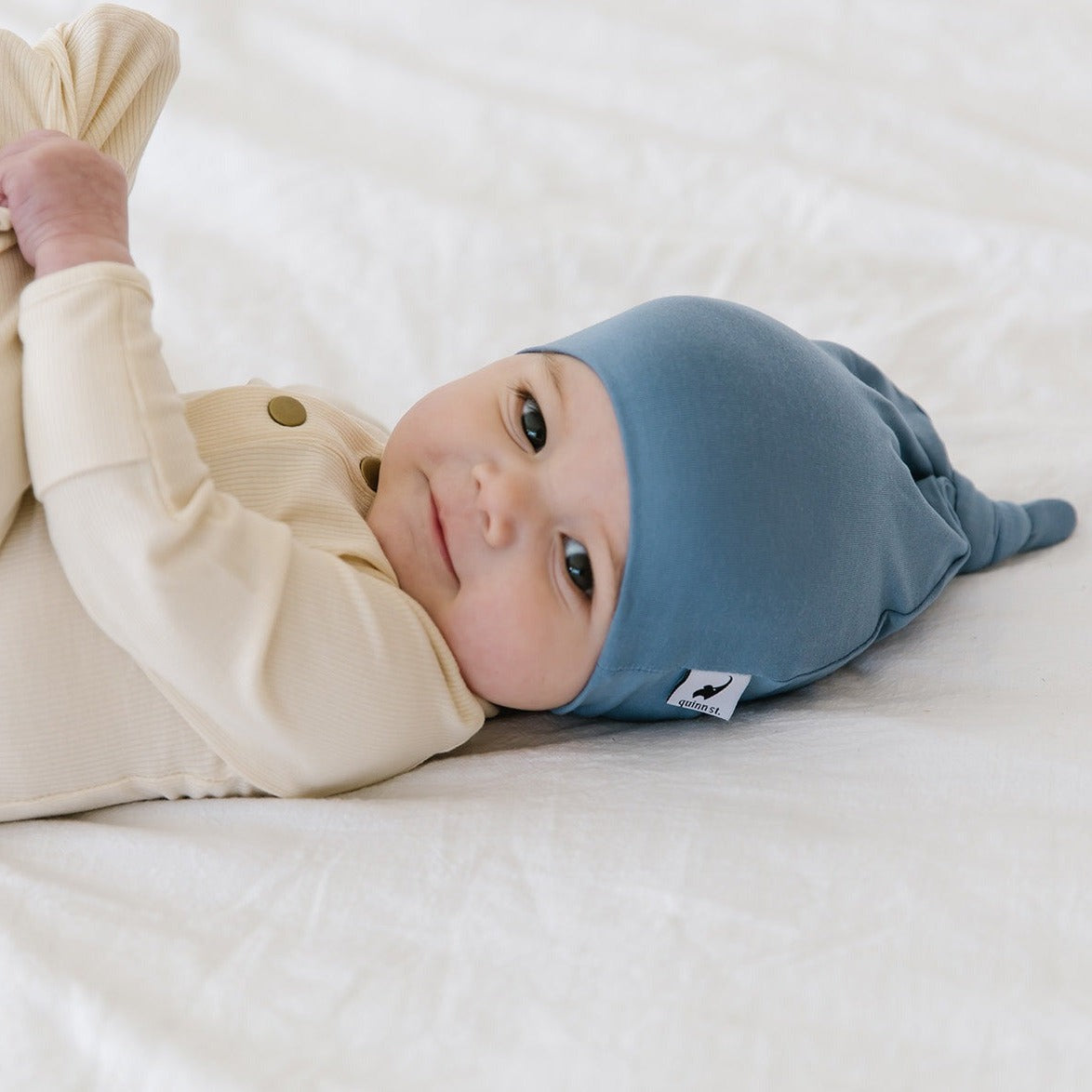 Baby wearing Quinn St Top Knot Hat - Sky