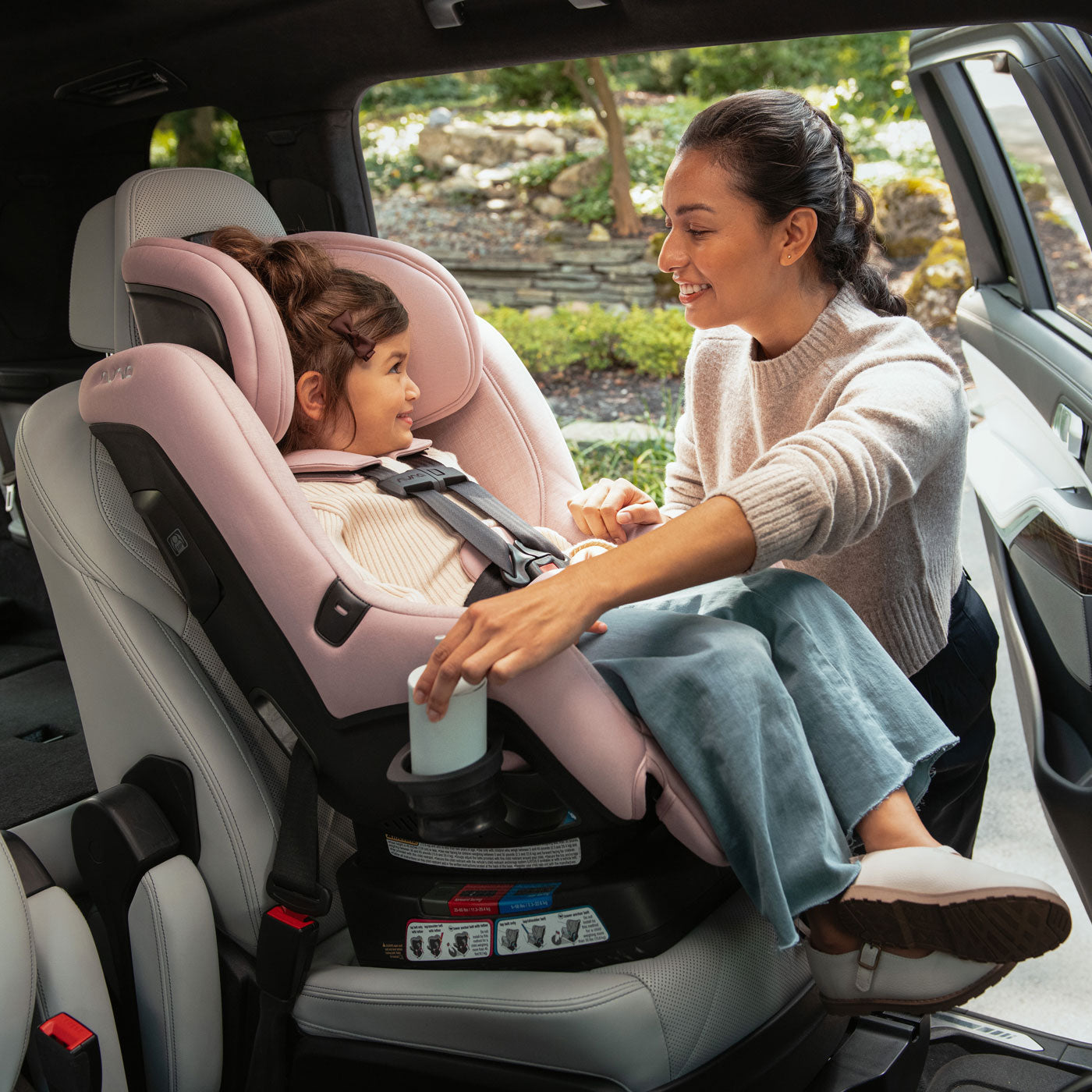 Mother with child riding in Nuna RAVA 2024 Convertible Car Seat