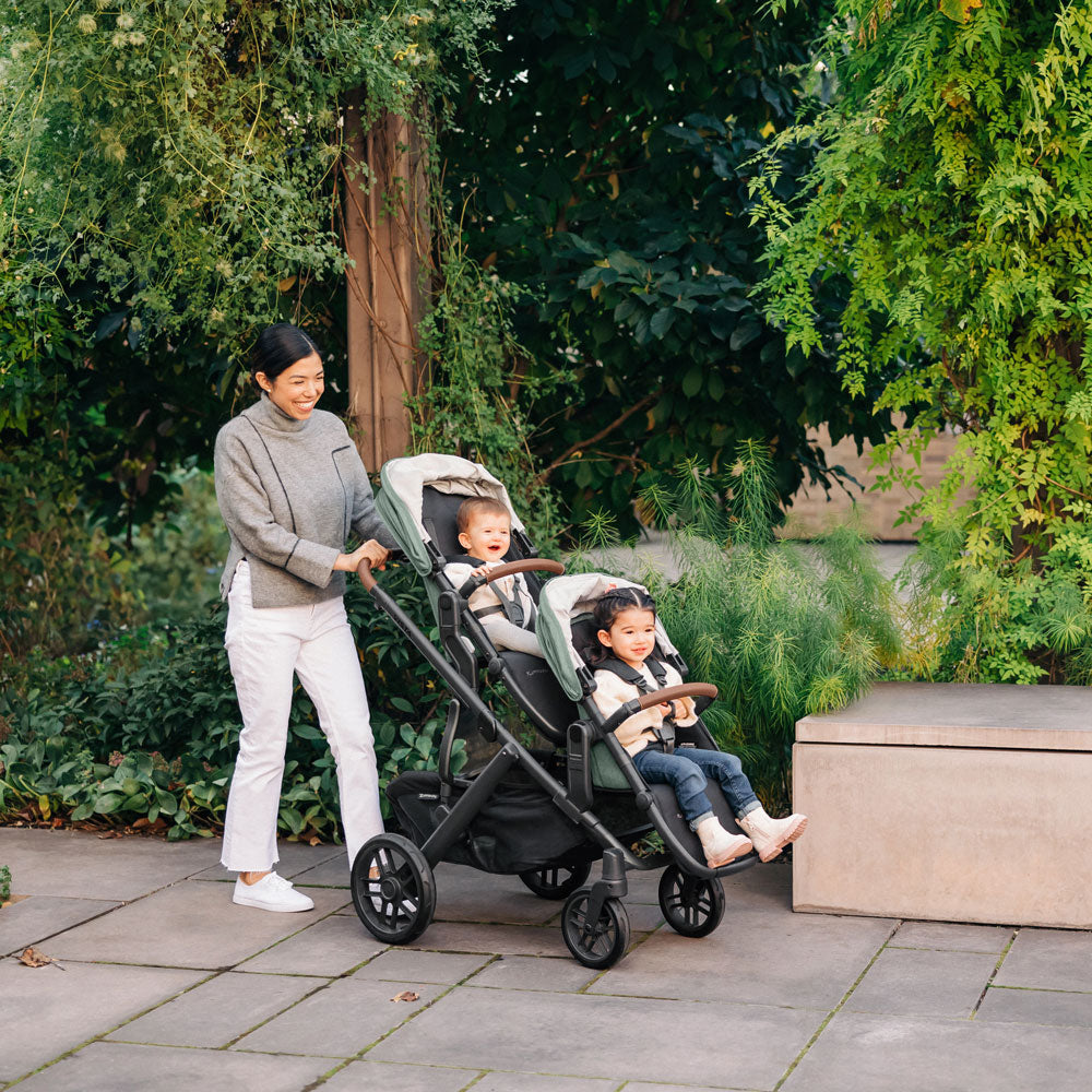 Mom pushes 2 children in UPPAbaby VISTA V2 and RumbleSeat V2+ Bundle - GWEN (Green Melange)