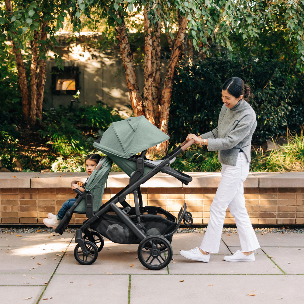 Mom pushes children in UPPAbaby VISTA V2 and RumbleSeat V2+ Bundle - GWEN (Green Melange)