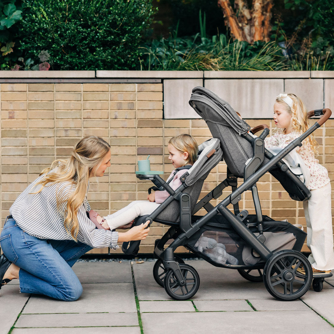 Mom adjusts footrest of UPPAbaby VISTA stroller with UPPAbaby VISTA V2 RumbleSeat V2+ - GREYSON (Charcoal Melange)