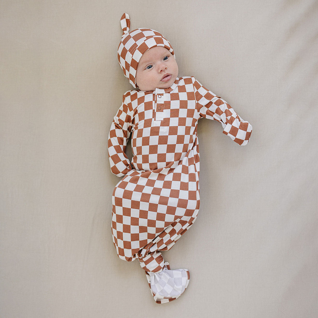 Baby wearing Mebie Baby Bamboo Newborn Knot Hat - Rust Checkered