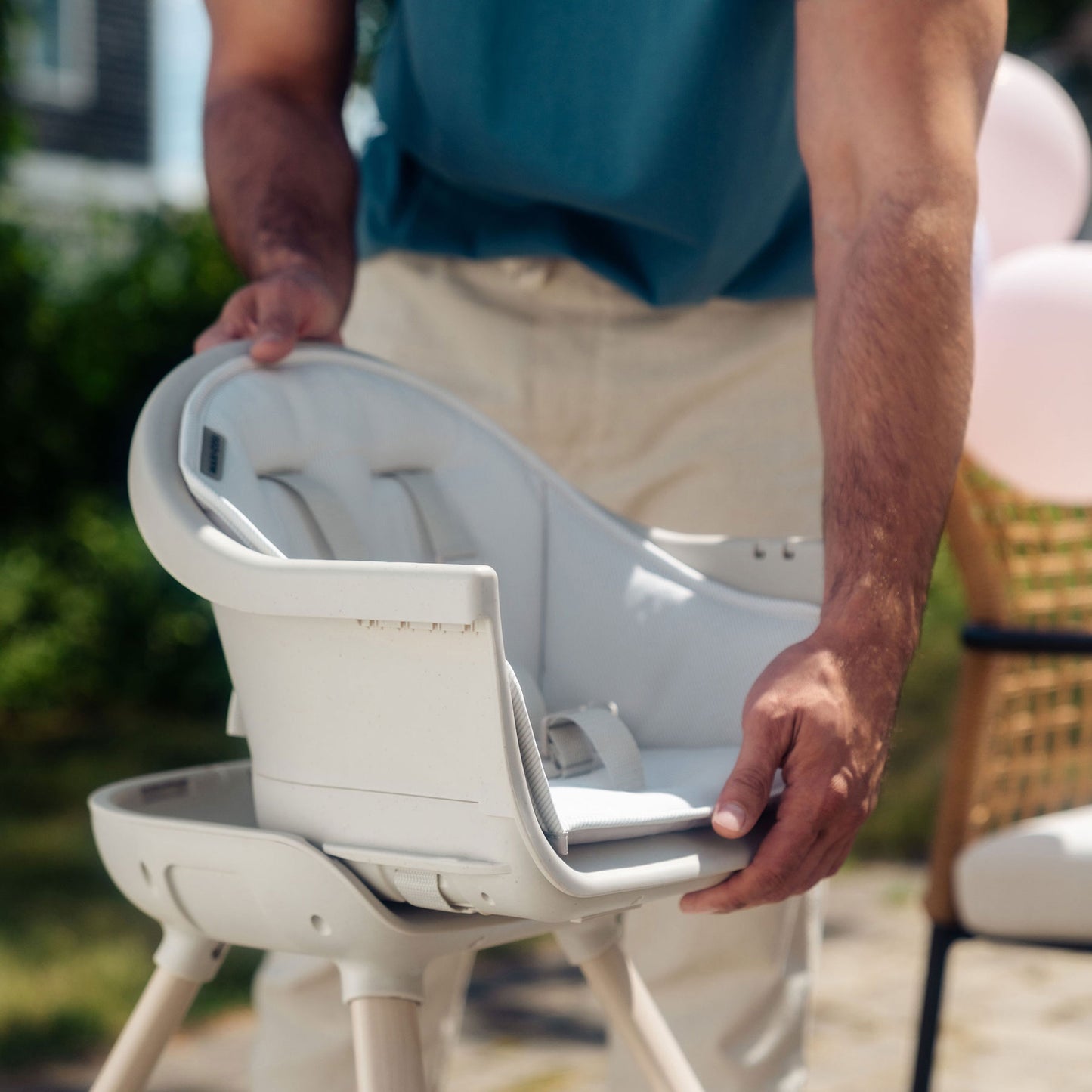 Dad adjusts seat of Maxi-Cosi Moa 8-in-1 High Chair - Classic Oat