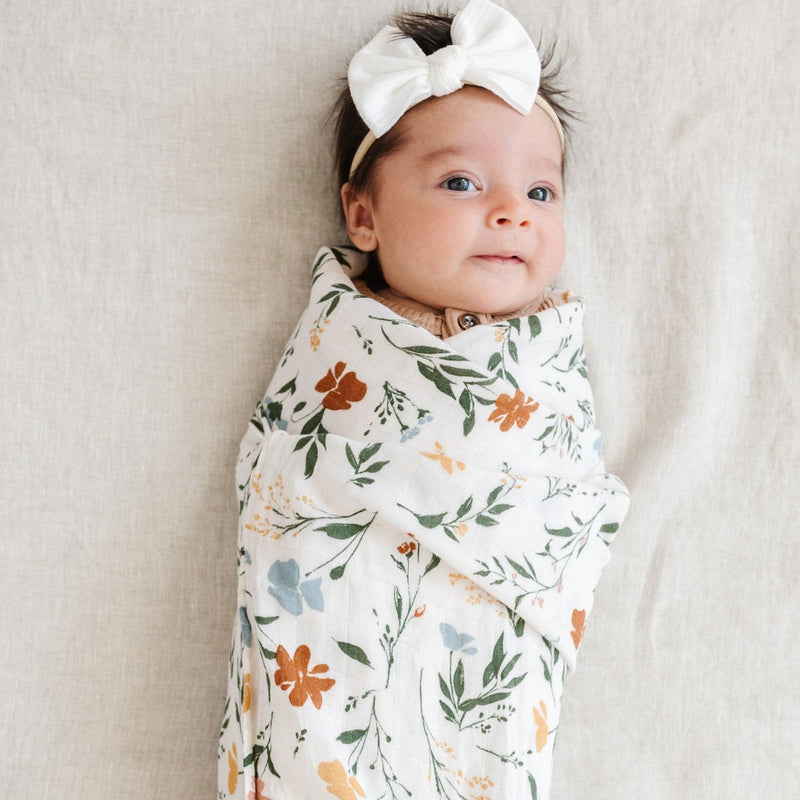 Baby girl wrapped in Saranoni Bamboo Muslin Swaddle Blanket - Fleurs