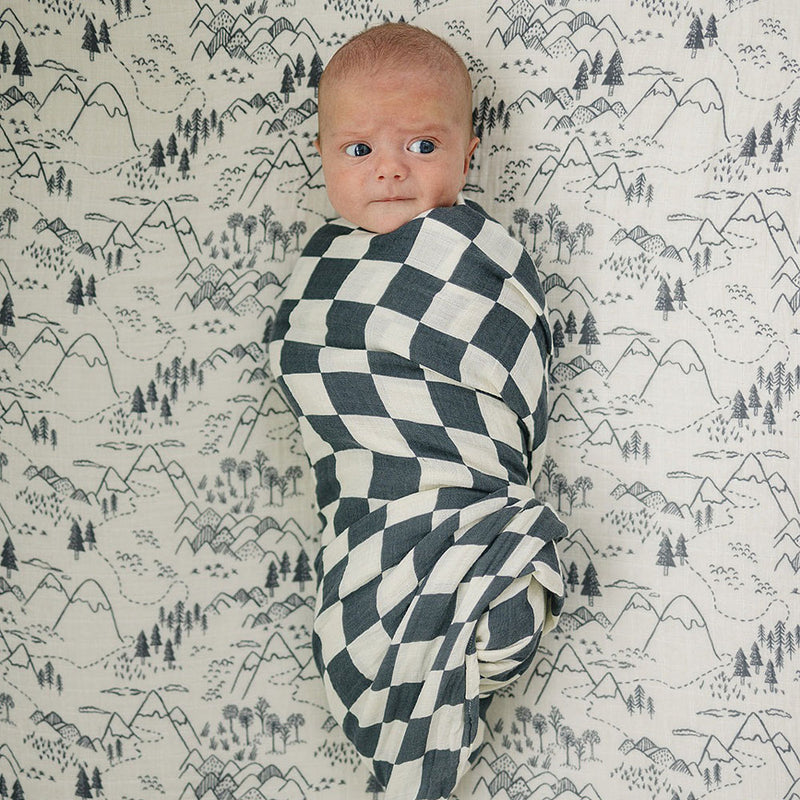 Baby wrapped in Mebie Baby Muslin Swaddle Blanket - Charcoal Checkered