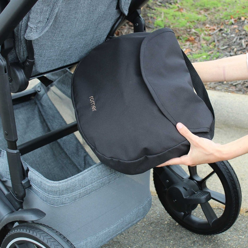 Woman putting Romer Tura Stroller Rain Cover in storage basket