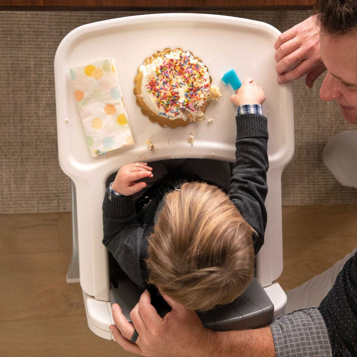 Baby eats first birthday cake while sitting in Nuna ZAAZ High Chair with MagneTech Secure Snap - Carbon