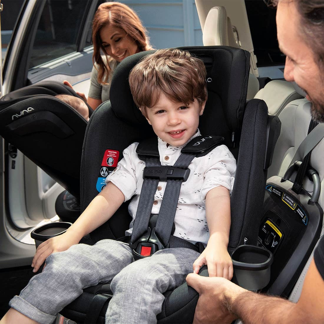 Dad puts toddler boy in Nuna REVV Rotating Convertible Car Seat - Caviar