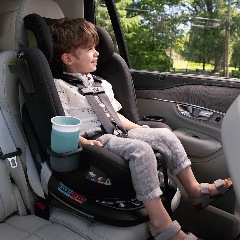 Little boy sits forward facing in Nuna REVV Rotating Convertible Car Seat - Caviar