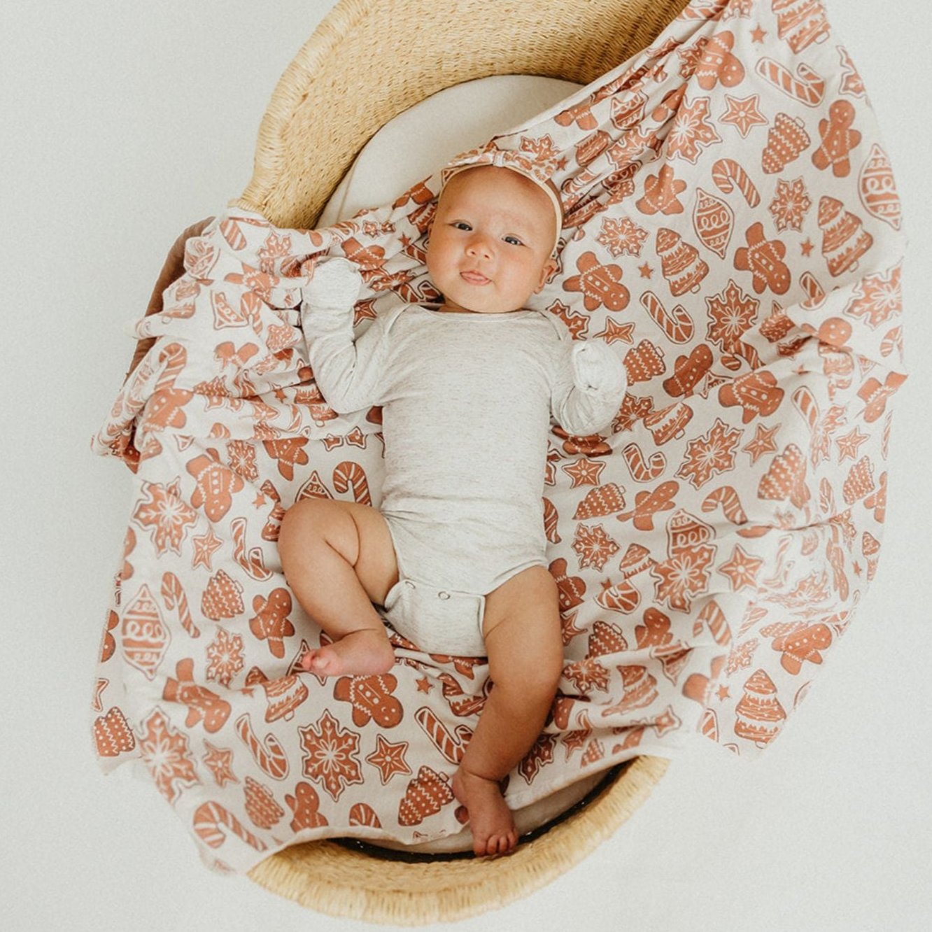 Baby lying on Copper Pearl Knit Swaddle Blanket - Gingerbread