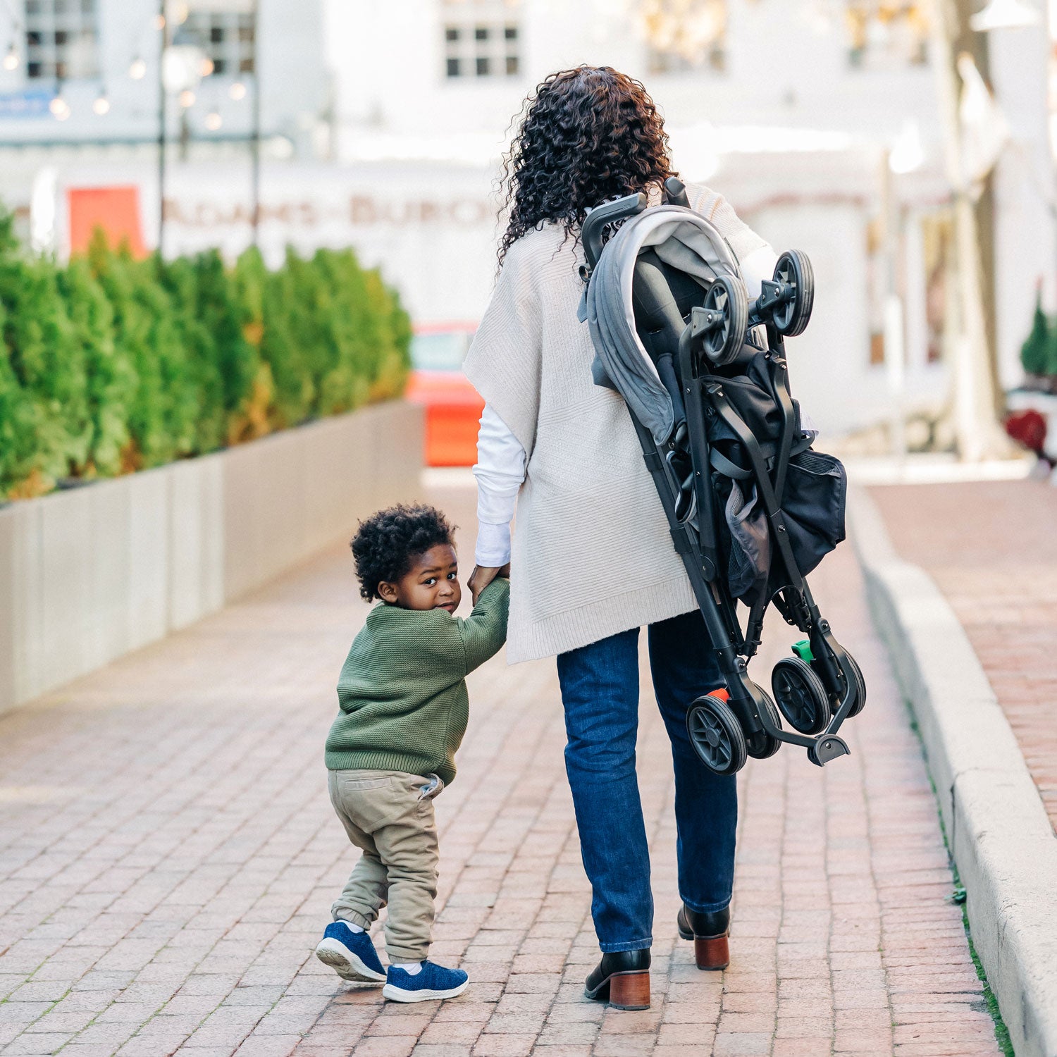 Woman carries folded UPPAbaby G-LUXE Stroller - Greyson