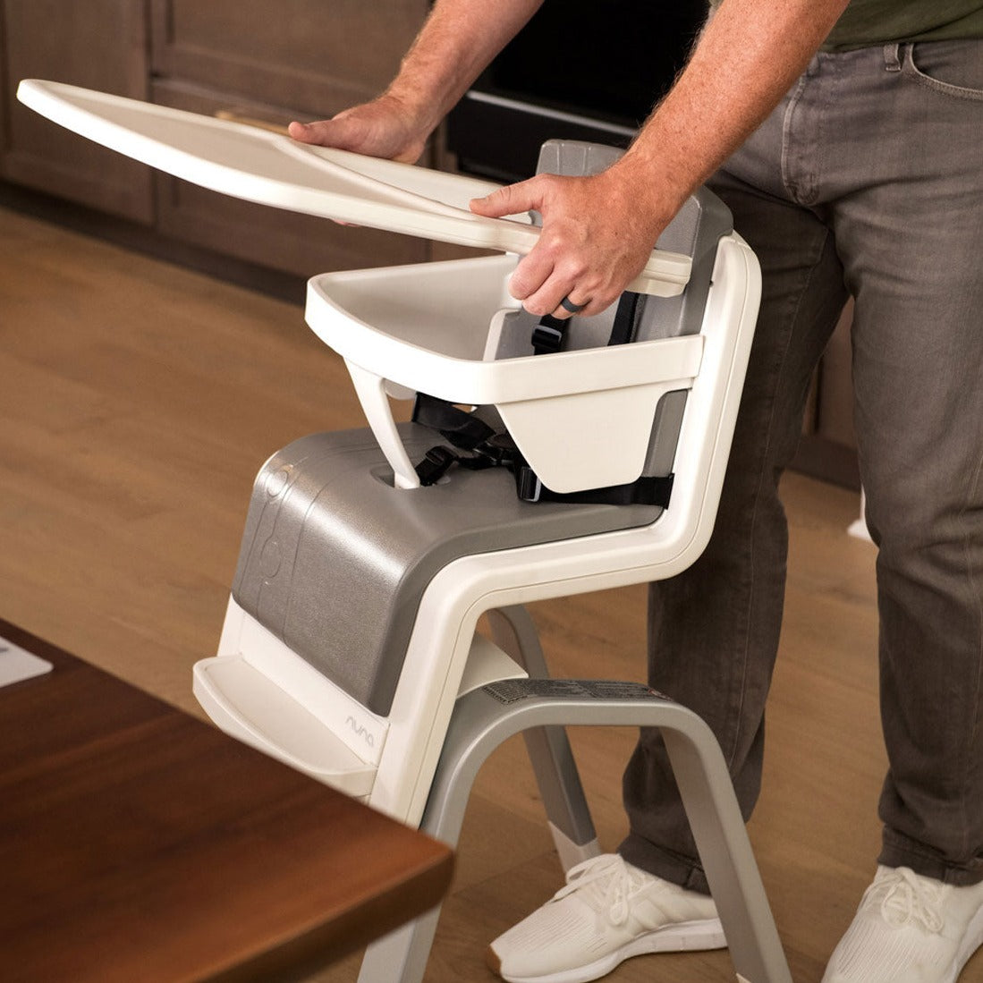 Dad putting tray onto Nuna ZAAZ High Chair with MagneTech Secure Snap - Carbon