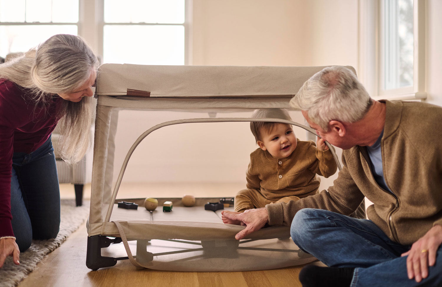 Grandparents playing with toddler inside UPPAbaby REMI Playard - Charlie