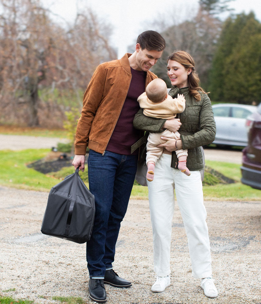 Parents holding baby and UPPAbaby REMI Playard