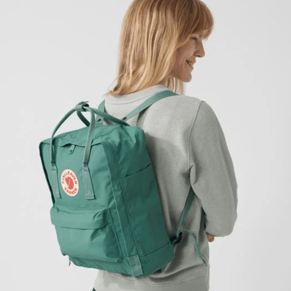 Woman wearing Fjallraven Kanken Classic Backpack - Frost Green