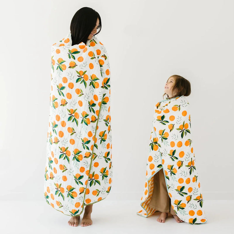 Mother and Child wrapped up in Clementine Kids Cotton Muslin Reversible Throw Blanket - Large - Clementine