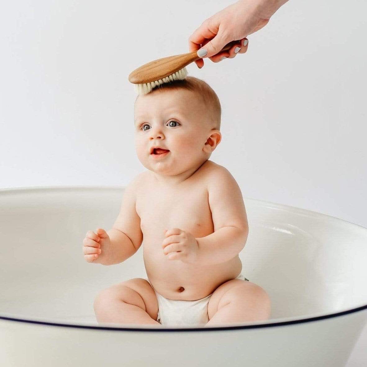 Baby being brushed with Kyte BABY Cradle Cap Brush - Bamboo